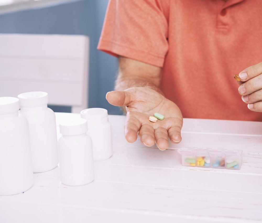 Closeup hands of senior man holding pills on his palm